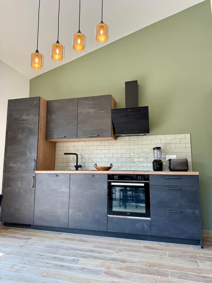 Cuisine entièrement équipée, murs tons olivier et crédence zellige — Villa Folacca